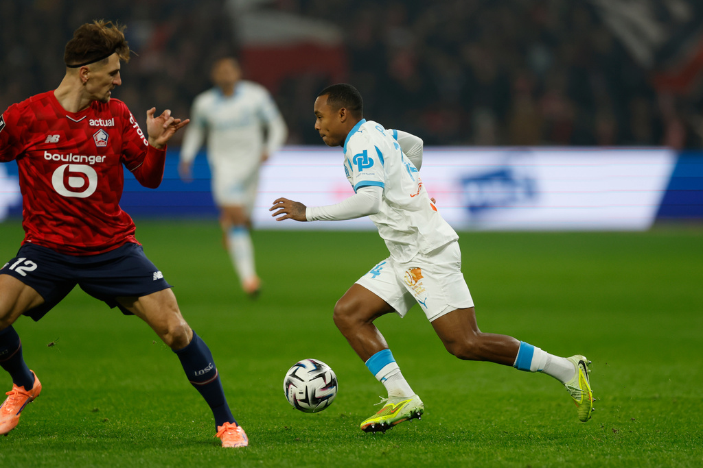 Lille's Thomas Meunier, left, and Marseille's Igor Paixao challenge for the ball during the French League One soccer match between Lille and Marseille in Villeneuve-d'Ascq, outside Lille, France, Friday, Dec. 5, 2025. (AP Photo/Jean-Francois Badias)