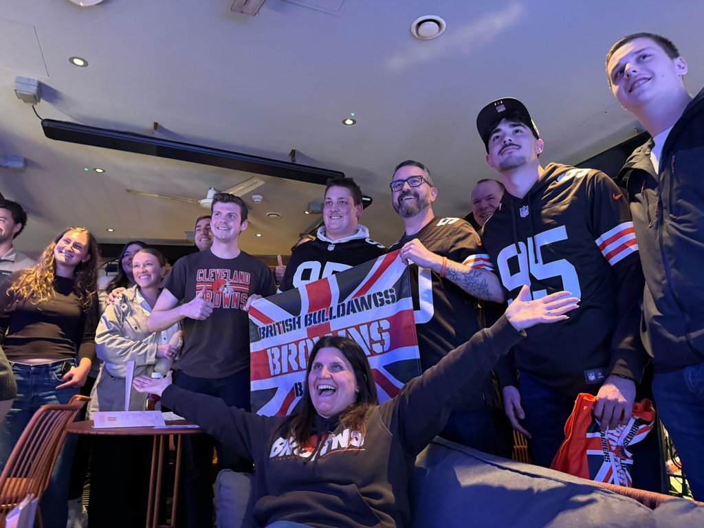 Kelly Burgess Taylor, seated, president of the British Bulldawgs Browns Backers, celebrates a Cleveland Browns victory with other club members at the Hippodrome Casino in London on Sept. 21, 2025. (AP Photo/Kenneth Maguire)