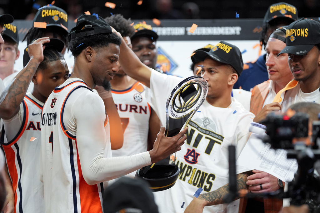 Auburn guard Kevin Overton, left, holds the trophy after he NCAA college basketball NIT Championship game agaisnt Tulsa, Sunday, April 5, 2026, in Indianapolis. (AP Photo/Abbie Parr)