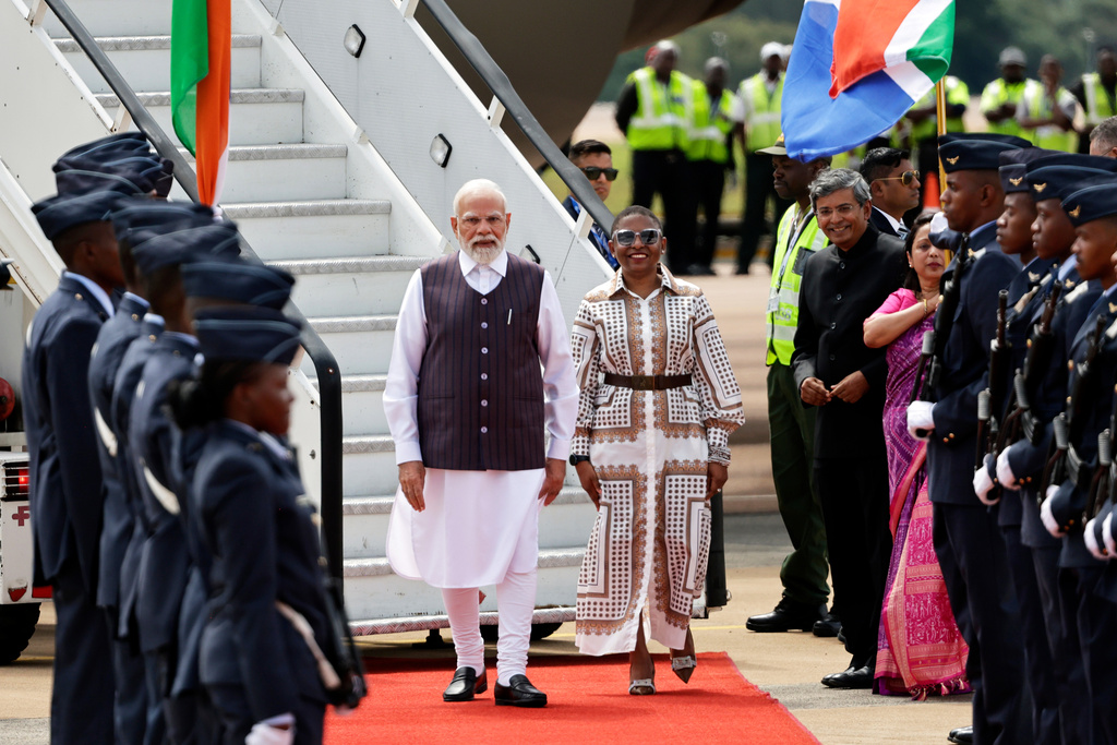 Indian Prime Minister Narendra Modi, left, is welcomed by Khumbudzo Ntshavheni, Minister in the Presidency on his arrival at the Air Force Base Waterkloof, near Pretoria, South Africa, Friday Nov. 21, 2025, ahead of the G20 Summit. (Kim Ludbrook/Pool Photo via AP)