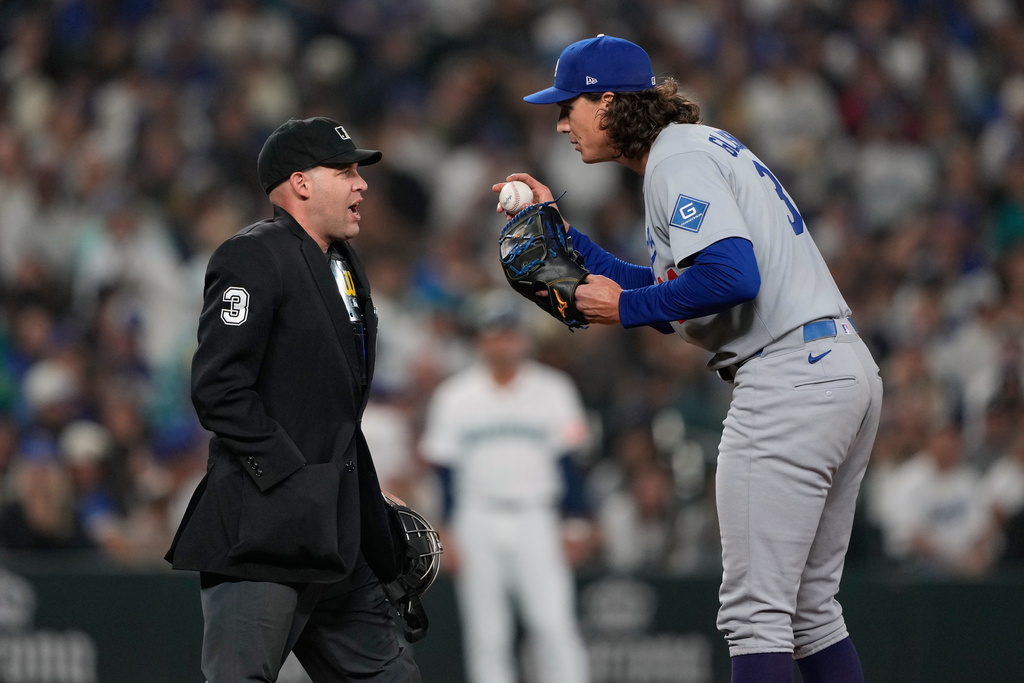 Los Angeles Dodgers starting pitcher Tyler Glasnow, right, talks to umpire Dan Merzel during the third inning of a baseball game, Saturday, Sept. 27, 2025, in Seattle. (AP Photo/Ryan Sun)