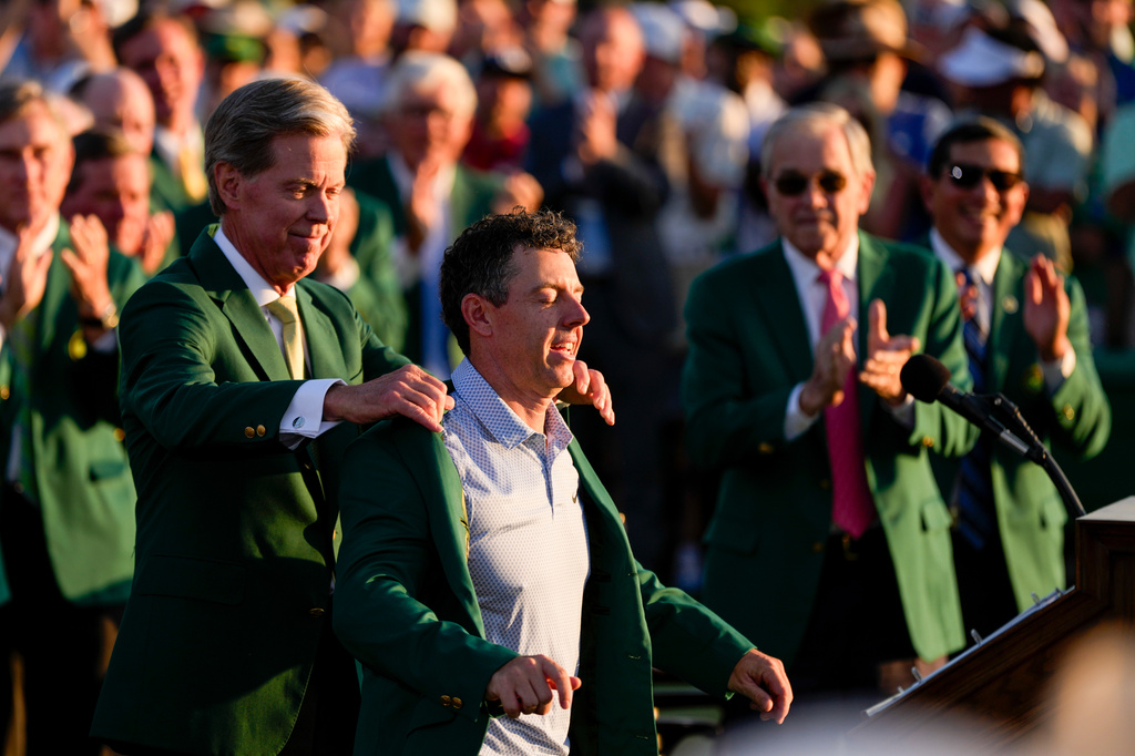 Augusta National Golf Club chairman Fred Ridley puts the green Jacket on Rory McIlroy, of Northern Ireland, after the Masters golf tournament at the Augusta National Golf Club, Sunday, April 12, 2026, in Augusta, Ga. (AP Photo/Matt Slocum)