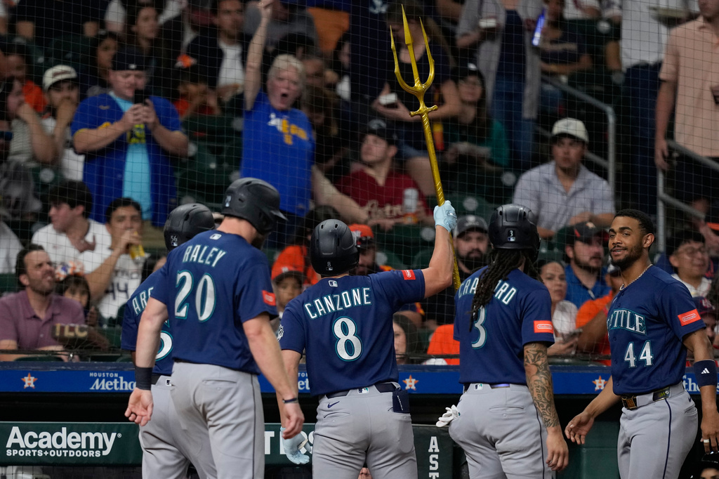 Seattle Mariners' Dominic Canzone (8) celebrates after hitting a grand slam against the Houston Astros during the fourth inning of a baseball game Tuesday, May 12, 2026, in Houston. (AP Photo/David J. Phillip)