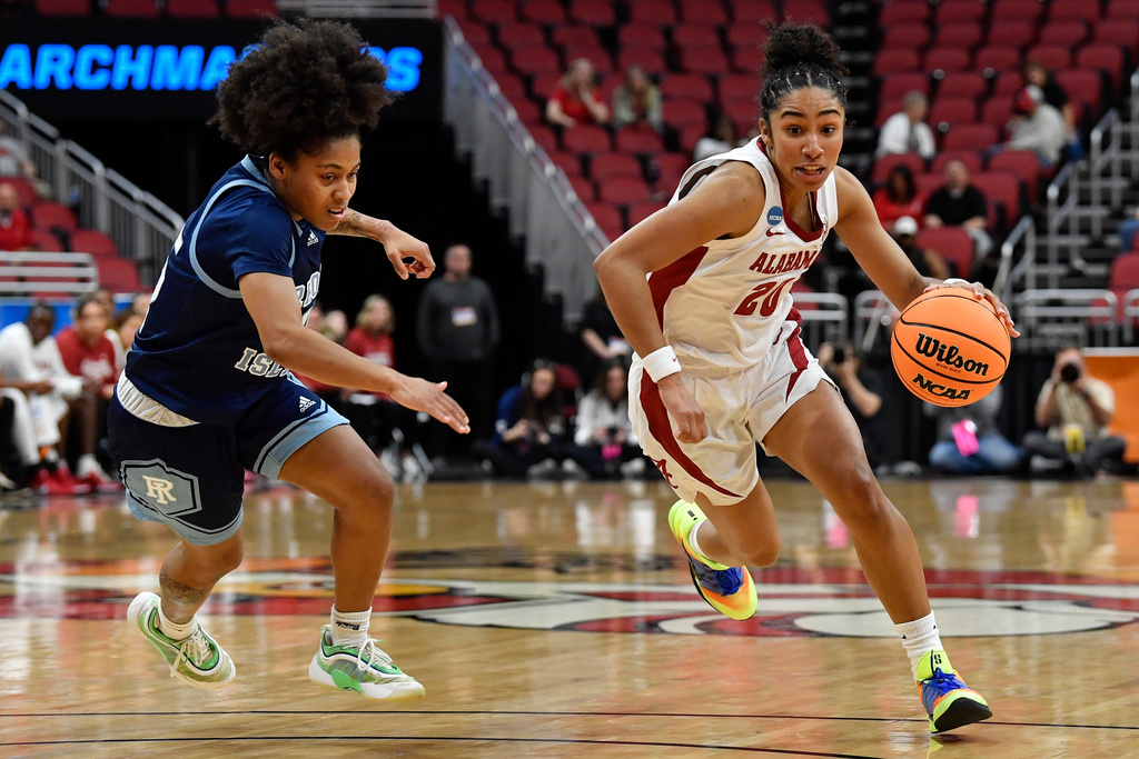 Alabama guard Diana Collins (20) drives past Rhode Island guard Sophia Vital (15) during the first half in the first round of the NCAA college basketball tournament, Saturday, March 21, 2026 in Louisville, Ky. (AP Photo/Timothy D. Easley)