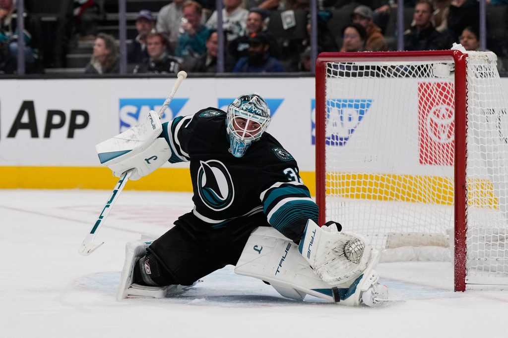 San Jose Sharks goaltender Alex Nedeljkovic deflects a shot during the second period of an NHL hockey game against the Carolina Hurricanes, Tuesday, Oct. 14, 2025, in San Jose, Calif. (AP Photo/Godofredo A. Vásquez)