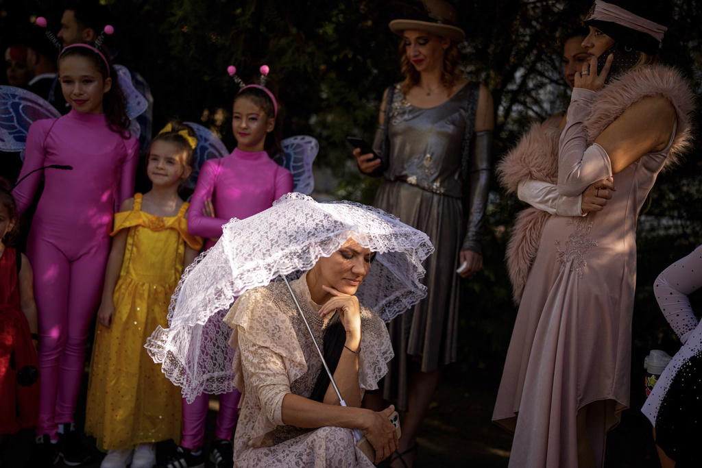 Entertainers wearing vintage styled outfits wait to take part in a parade marking the day when the Romanian capital was first mentioned in historical records, 566 years ago, in Bucharest, Romania, Saturday, Sept. 20, 2025. (AP Photo/Andreea Alexandru)