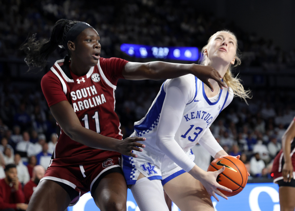 Kentucky's Clara Strack (13) looks for a shot near South Carolina's Madina Okot (11) during an NCAA college basketball game in Lexington, Ky., Sunday, March 1, 2026. (AP Photo/James Crisp)