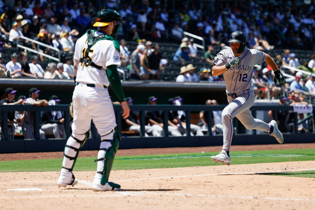 Colorado Rockies' Kyle Karros (12) runs home to score on a sacrifice fly by Braxton Fulford (37) during the fifth inning of a baseball game against the Athletics, Sunday, June 14, 2026, in Las Vegas. (AP Photo/Caroline Brehman)