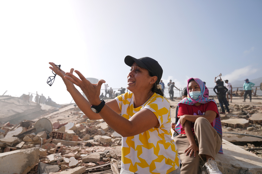 FILE - People search for missing relatives at the collapsed building where they lived, two days after earthquakes struck La Guaira, Venezuela, June 26, 2026. (AP Photo/Ariana Cubillos, File)