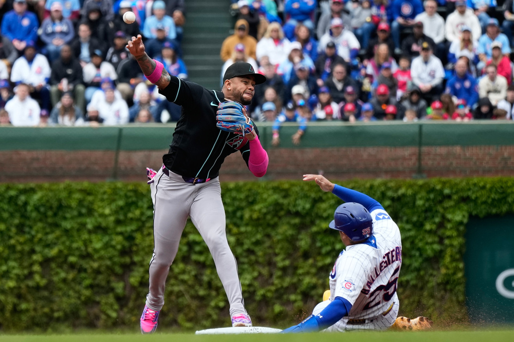 Arizona Diamondbacks second baseman Ketel Marte, left, throws out Chicago Cubs' Alex Bregman at first base after forcing out Moisés Ballesteros, right, during the first inning of a baseball game in Chicago, Sunday, May 3, 2026. (AP Photo/Nam Y. Huh)