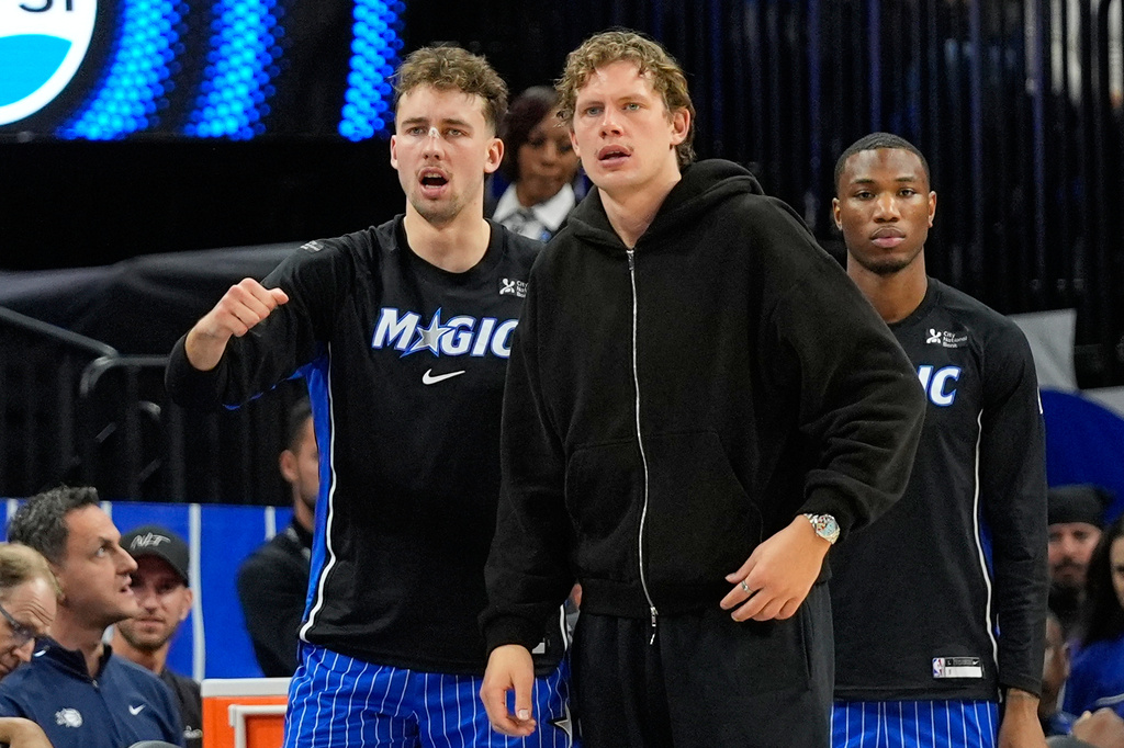 **HOLD FOR STORY BY ROB MADDIE**Orlando Magic forward Franz Wagner, left, and brother Moritz Wagner watch the first half of an NBA basketball game against the Golden State Warriors, Tuesday, Nov. 18, 2025, in Orlando, Fla. (AP Photo/John Raoux)