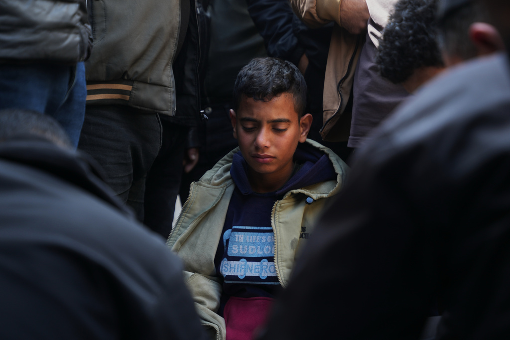 A youth mourns over the body of a Palestinian policeman, Khaled Al-Zayan, who was killed in an Israeli military strike, during his funeral in Khan Younis, southern Gaza Strip, Friday, Feb. 27, 2026. (AP Photo/Abdel Kareem Hana)