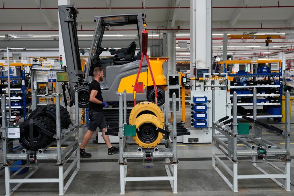 Employees at forklift and warehouse manufacturer Jungheinrich work on the assembly line in Moosburg, Germany, Tuesday, Aug. 25, 2026. (AP Photo/Matthias Schrader)