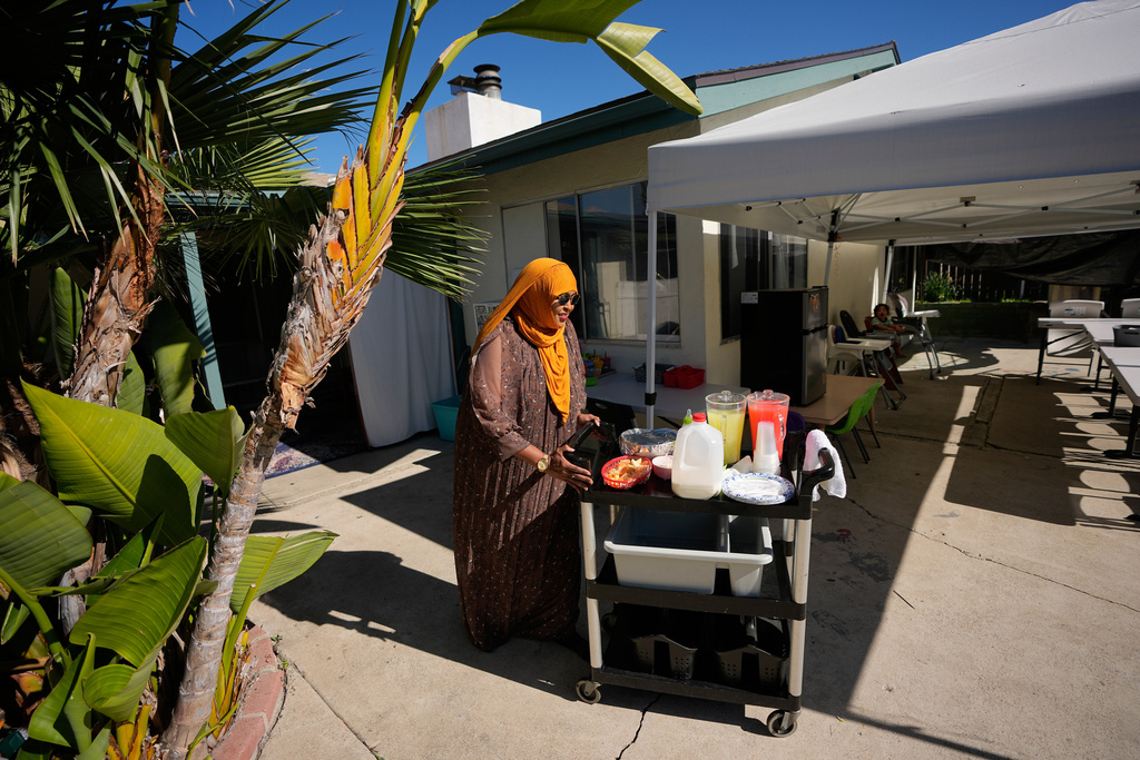 Samsam Khalif prepares for meal time at her home-based child care center Friday, Jan. 30, 2026, in San Diego. (AP Photo/Gregory Bull)