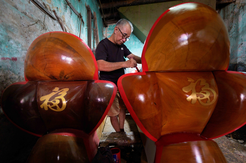 Goh Khuay Hou applies red paint to a Mei Hua coffin at his family workshop in Muar, Malaysia, Tuesday, July 14, 2026. (AP Photo/Vincent Thian)