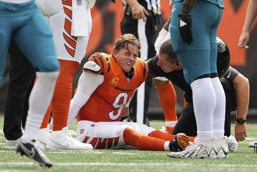 Cincinnati Bengals quarterback Joe Burrow (9) grimaces aft being sacked by Jacksonville Jaguars defensive tackle Arik Armstead (91) during the first half of an NFL football game, Saturday, Sept. 14, 2024, in Cincinnati. (AP Photo/Carolyn Kaster)