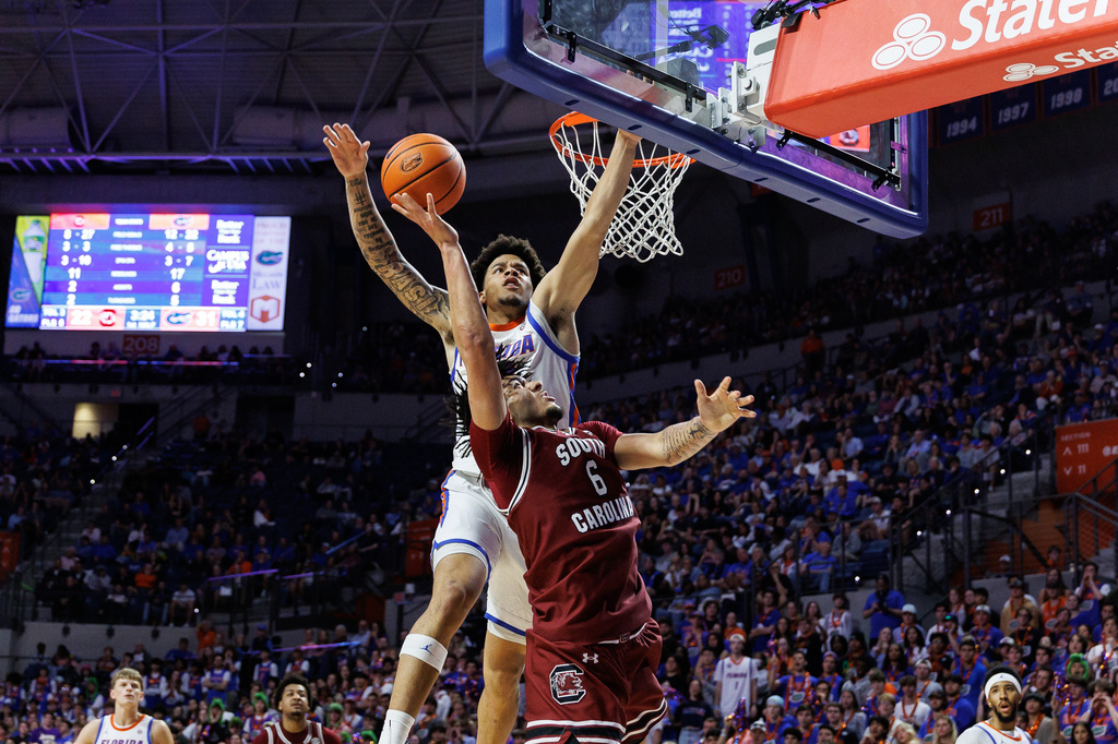 Florida guard Isaiah Brown (20) defends a shot by South Carolina forward EJ Walker (6) during the first half of an NCAA college basketball game, Tuesday, Feb. 17, 2026, in Gainesville, Fla. (AP Photo/Chris Watkins)