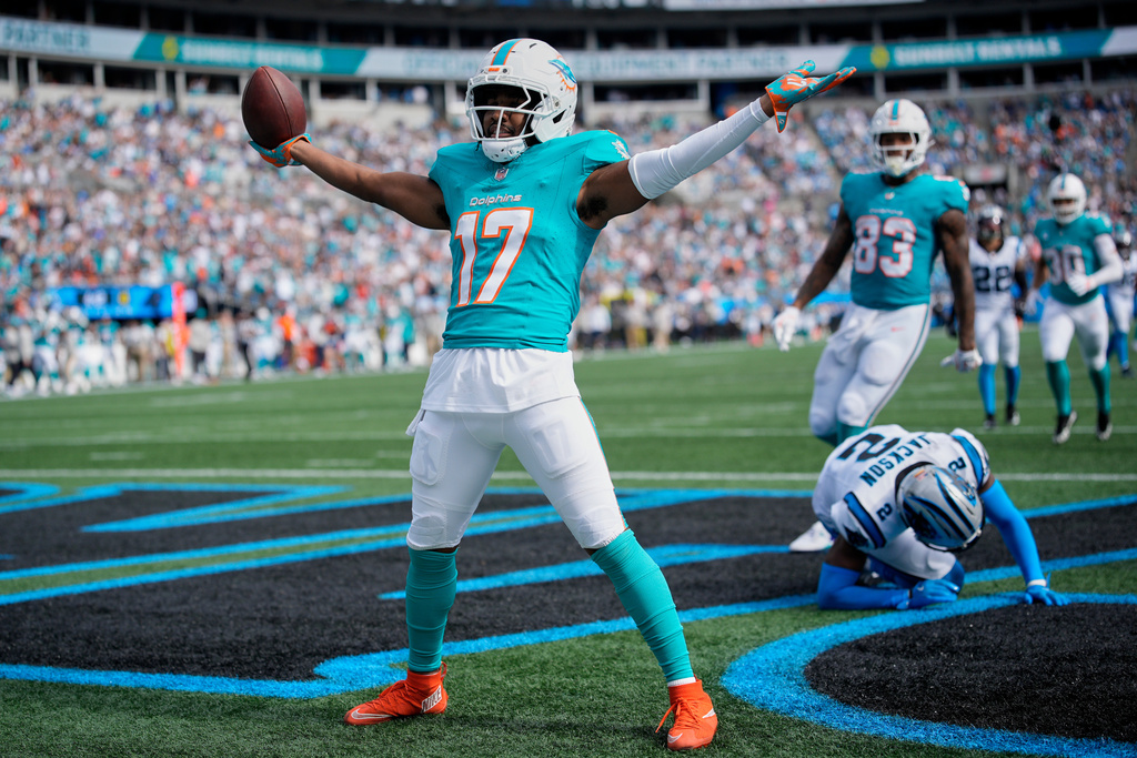 Miami Dolphins wide receiver Jaylen Waddle celebrates after scoring ahead of Carolina Panthers cornerback Mike Jackson during the second half of an NFL football game, Sunday, Oct. 5, 2025, in Charlotte, N.C. (AP Photo/Jacob Kupferman)