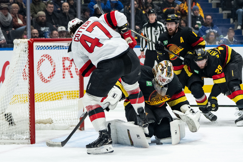 Vancouver Canucks goaltender Kevin Lankinen (32) stops New Jersey Devils' Paul Cotter (47) during the second period of an NHL hockey game in Vancouver, British Columbia, Friday, Jan. 23, 2026. (Ethan Cairns/The Canadian Press via AP)
