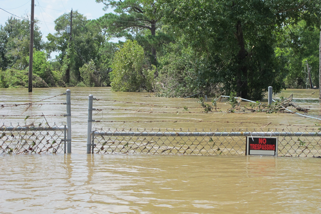 FILE - A barbed-wire fence encircles the Highlands Acid Pit that was flooded by water from the nearby San Jacinto River in the aftermath of Hurricane Harvey in Highlands, Texas on Aug. 31, 2017. (AP Photo/Jason Dearen)