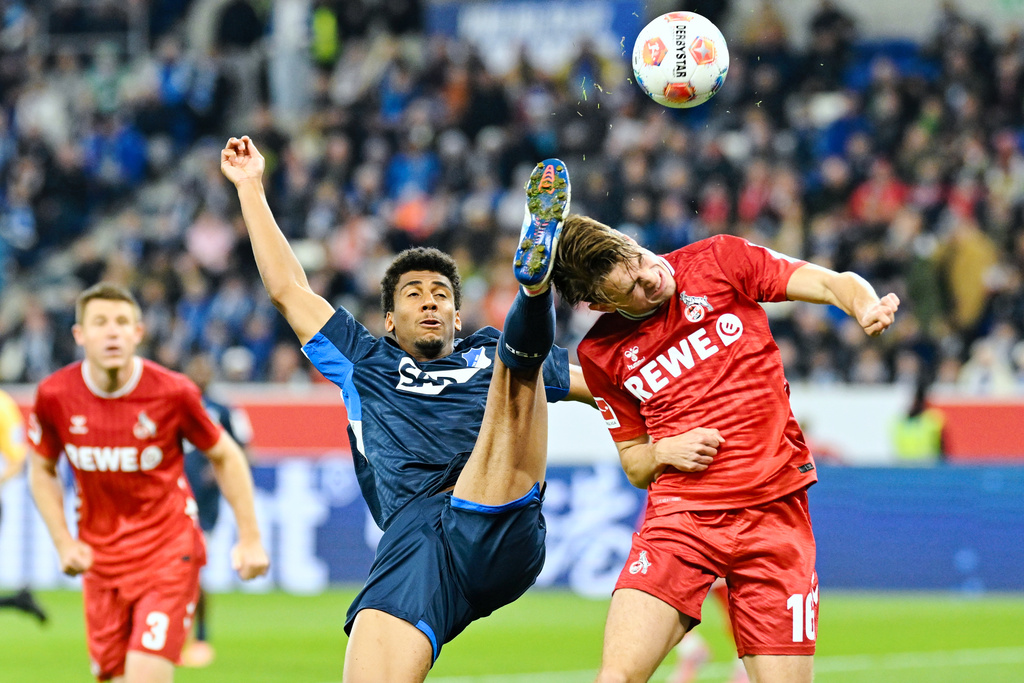 Hoffenheim's Bernardo, left, and Köln's Jakub Kamiński battle for the ball during Bundesliga soccer match between TSG 1899 Hoffenheim and 1. FC Köln, Friday, Oct. 3,2025, in Sinsheim, Germany. (Uwe Anspach/dpa via AP)