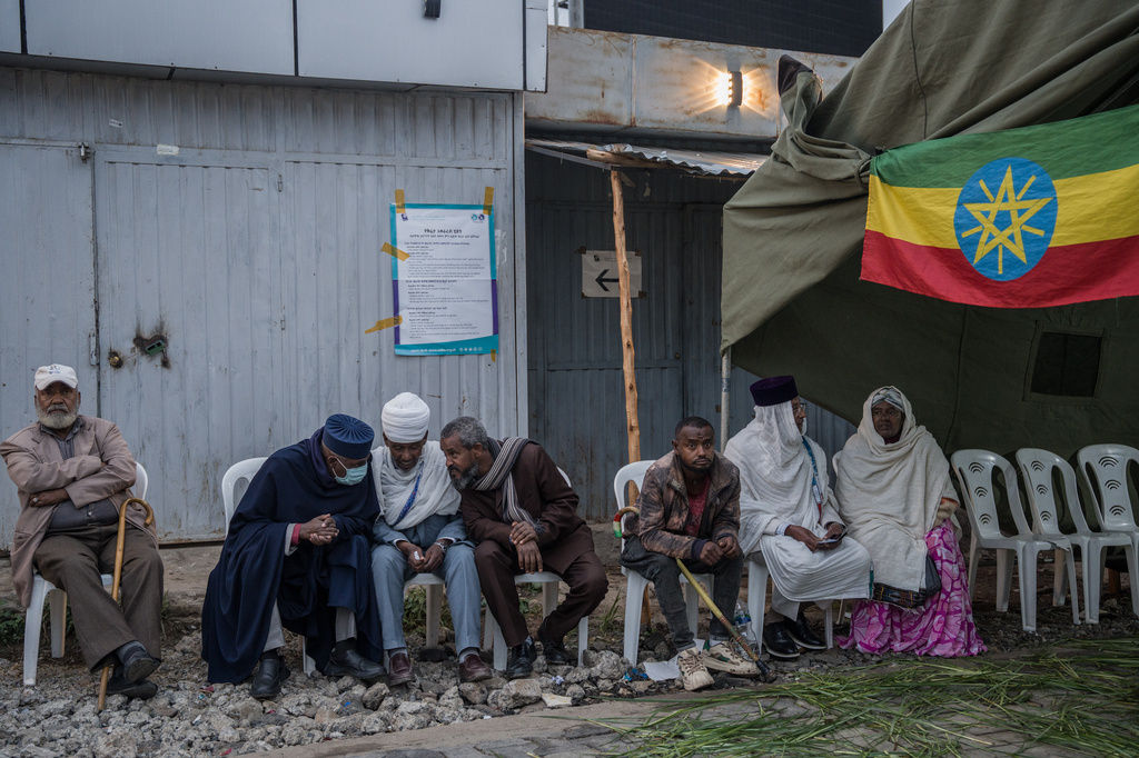 People sit outside a polling station before casting their votes in the general election in Addis Ababa, Ethiopia, on Monday, June 1, 2026. (AP Photo/Amanuel Sileshi)