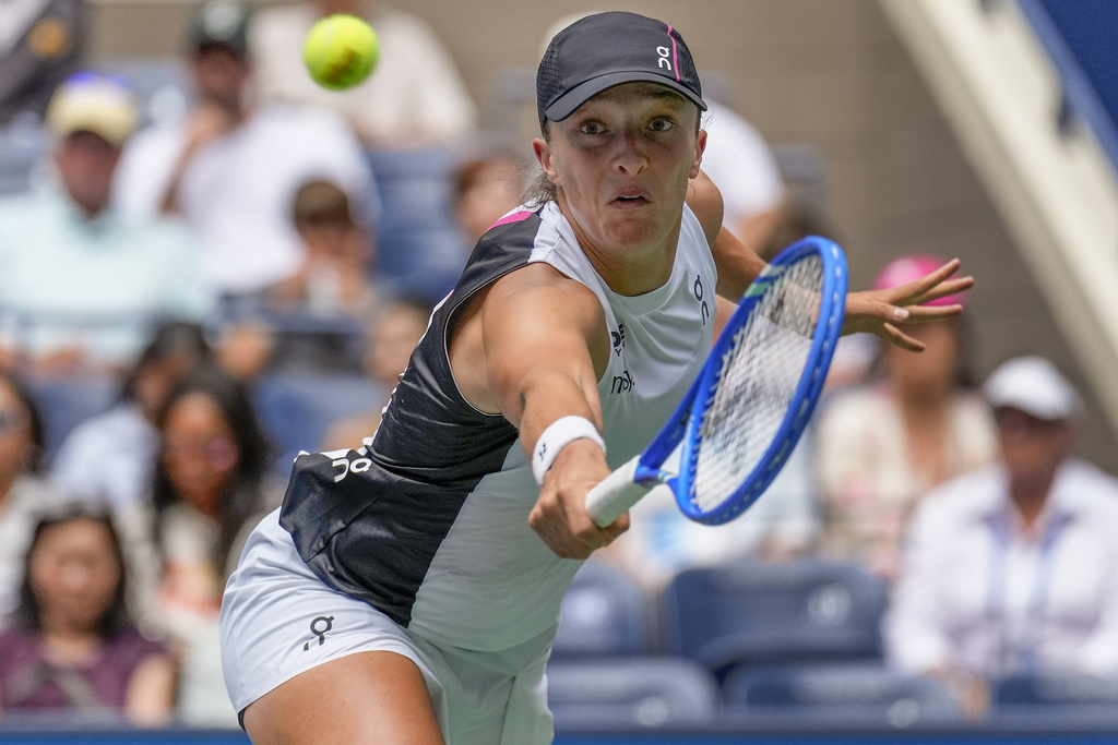 Iga Swiatek, of Poland, returns a shot to Suzan Lamens, of the Netherlands, during the second round of the U.S. Open tennis championships, Thursday, Aug. 28, 2025, in New York. (AP Photo/Seth Wenig)
