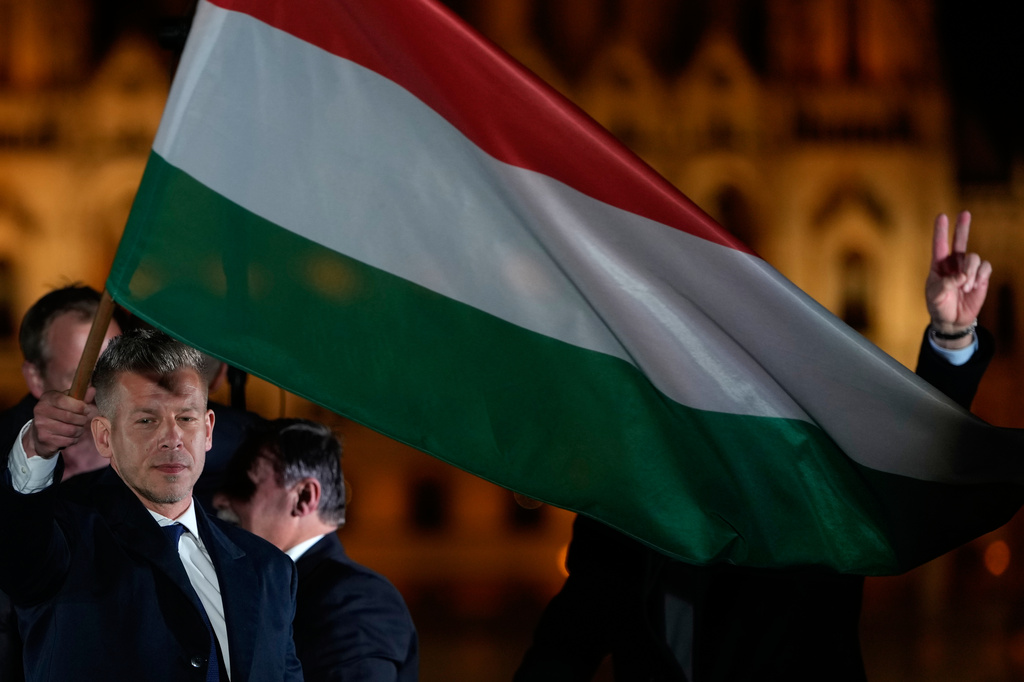 Peter Magyar, the leader of the opposition Tisza party waves a national flag after claiming victory in a parliamentary election in Budapest, Hungary, Sunday, April 12, 2026. (AP Photo/Darko Bandic)