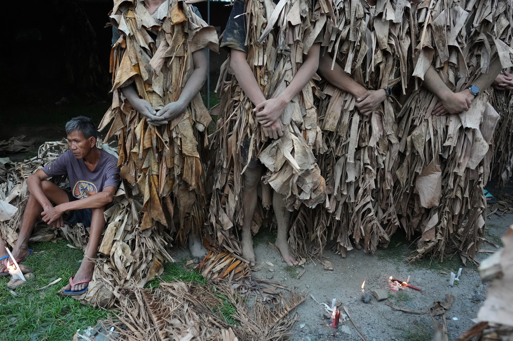 A Catholic devotee covered in mud and dried banana leaves participates in the mud people festival on the feast day of Saint John the Baptist at Bibiclat, Nueva Ecija province, northern Philippines on Wednesday, June 24, 2026. (AP Photo/Aaron Favila)