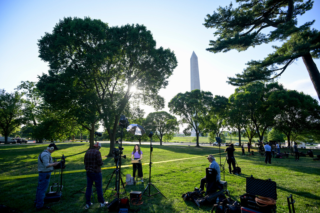 Journalists report as U.S. Secret Service and local police remain after a person was shot by law enforcement near the Washington Monument in Washington, Monday, May 4, 2026. (AP Photo/Rod Lamkey Jr.)