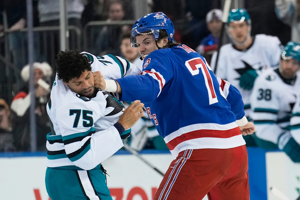 FILE - New York Rangers' Matt Rempe, right, fights with San Jose Sharks' Ryan Reaves (75) during the first period of an NHL hockey game in New York, Oct. 23, 2025. (AP Photo/Seth Wenig, File)