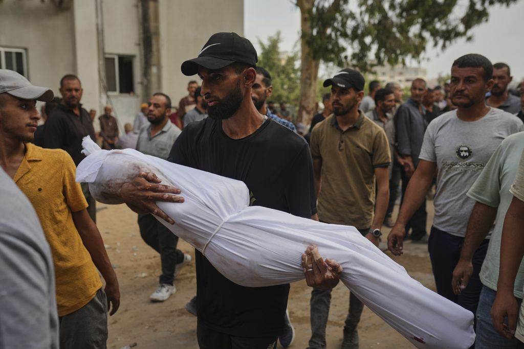 A relative carries the body of Palestinian child Muath Al-Basus, who was killed in an Israeli military strike, during his funeral outside Shifa Hospital in Gaza City, Thursday, Sept. 4, 2025. (AP Photo/Jehad Alshrafi)