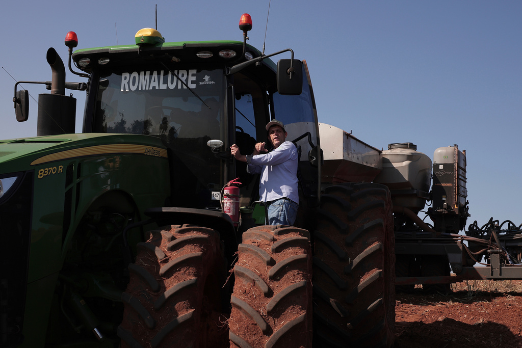 FILE - Farmer Andrey Rodrigues, who chairs the soybean farmers association in Sao Paulo state, talks to a worker operating a tractor pulling a seeder during the planting season on the Morada do Sol farm in Santa Cruz do Rio Pardo, Brazil, Oct. 15, 2025. (AP Photo/Ettore Chiereguini, File)