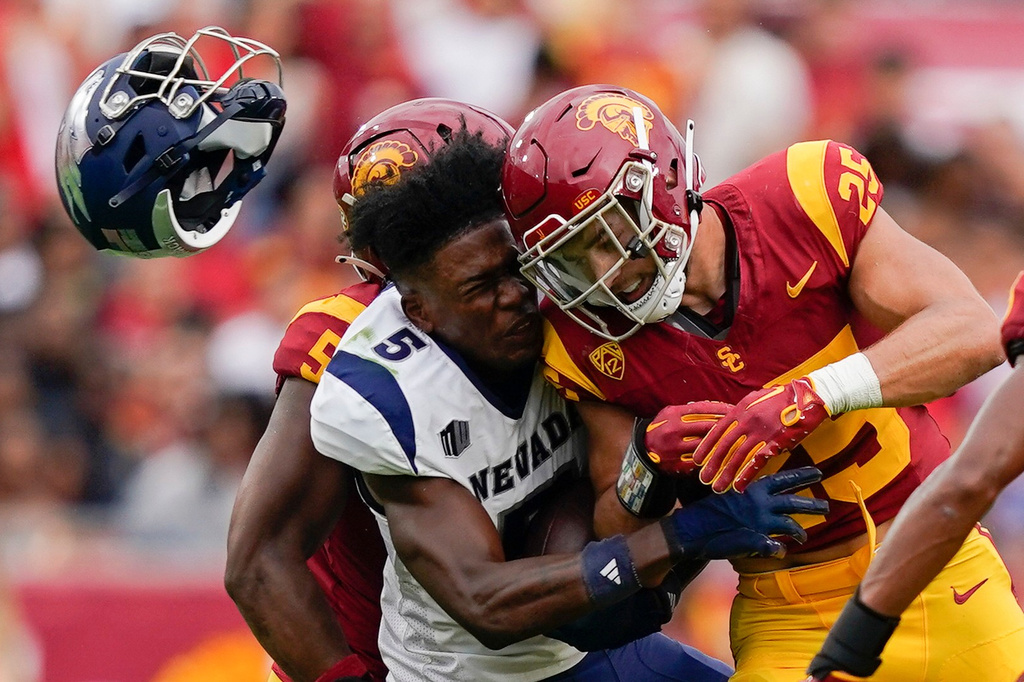 FILE - Nevada wide receiver Dalevon Campbell loses his helmet after being hit by Southern California linebacker Tackett Curtis, drawing a targeting penalty, during the first half of an NCAA college football game, in Los Angeles, Sept. 2, 2023. (AP Photo/Ryan Sun, File)