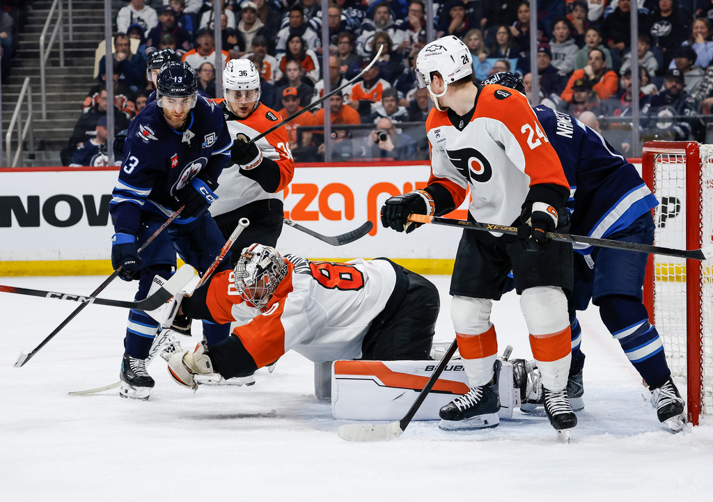 Philadelphia Flyers goaltender Dan Vladar (80) makes a save against the Winnipeg Jets during second period NHL action in Winnipeg, Saturday, April 11, 2026. (John Woods/The Canadian Press via AP)