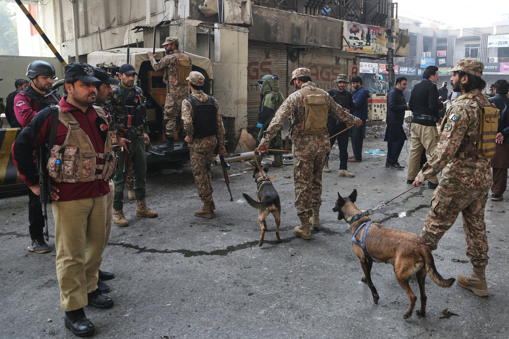 Army soldiers arrive with sniffer dogs after suicide bombers attacked the headquarters of the Federal Constabulary (FC), in Peshawar, Pakistan, Monday, Nov. 24, 2025. (AP Photo/Muhammad Zubair)