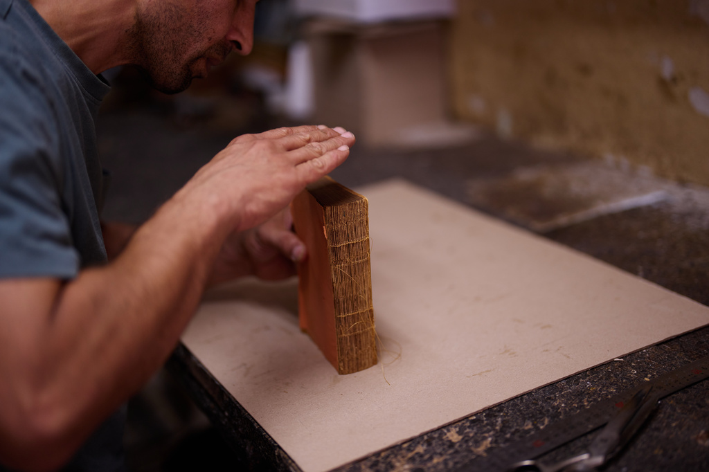 Bookbinder Ibrahim Yildirim repairs an old Quran in his workshop in Istanbul, Turkey, Saturday, Aug. 8, 2026. (AP Photo/Francisco Seco)