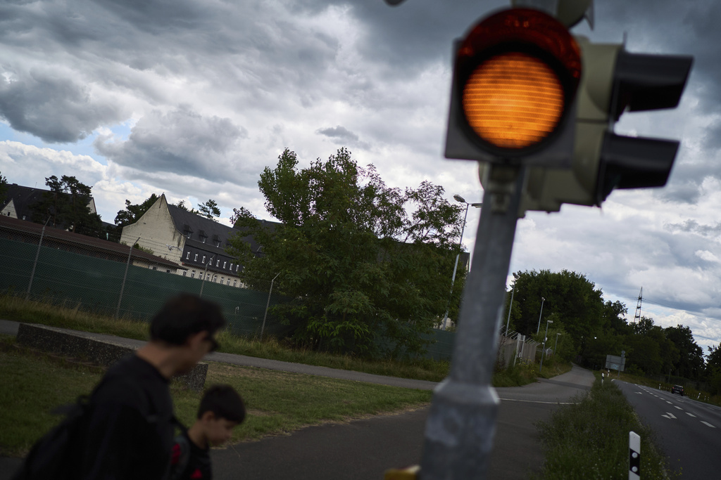 Former Xinjiang government engineer Nureli Abliz, and his son, Ilyon, 9, leave their refugee camp at the Tompkins Barracks, a former U.S. Army installation, in Schwetzingen, Germany, Wednesday, July 23, 2025. (AP Photo/David Goldman)