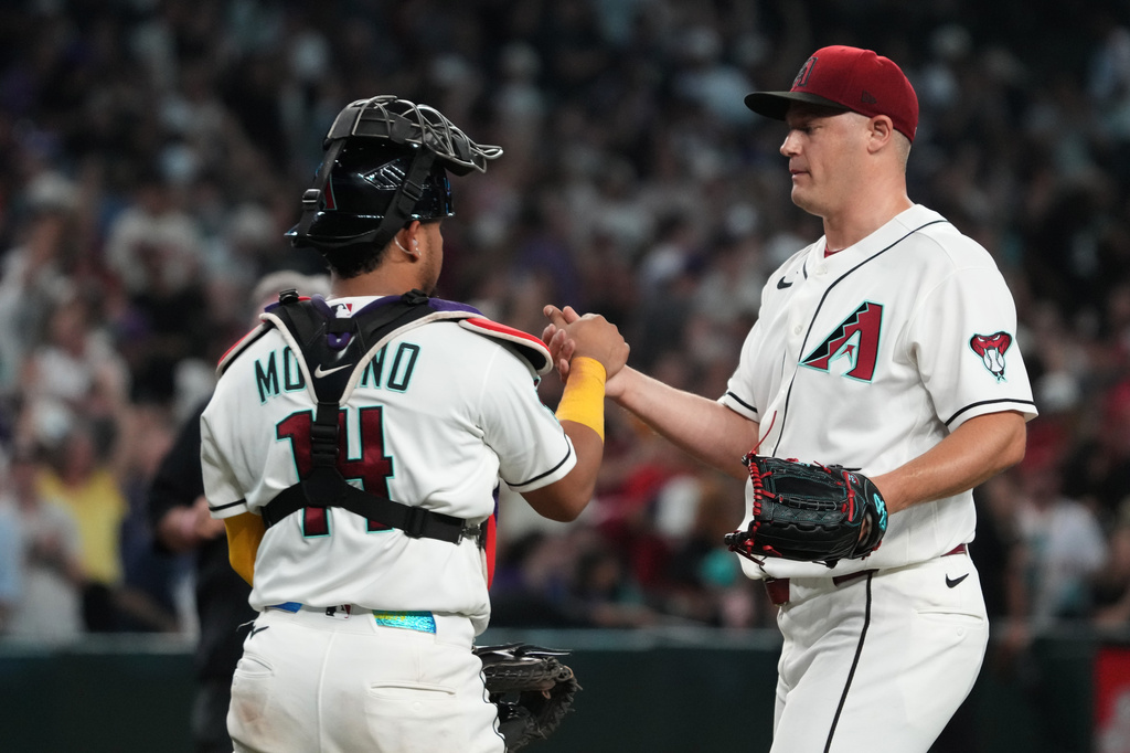 Arizona Diamondbacks catcher Gabriel Moreno (14) and pitcher Paul Sewald celebrate after defeating the Los Angeles Angels during a baseball game, Monday, June 15, 2026, in Phoenix. (AP Photo/Rick Scuteri)