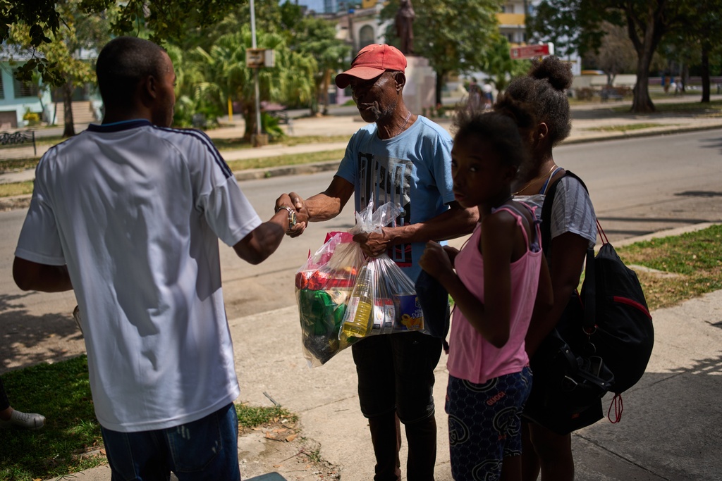 State-run bodega worker Roberto Román, left, shakes hands with Guillermo Beltran, after Beltran received bags of Mexican humanitarian assistance, in Havana, Cuba, Thursday, Feb. 19, 2026. (AP Photo/Ramon Espinosa)