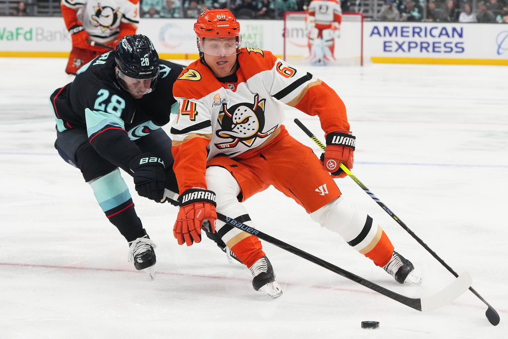 Seattle Kraken defenseman Joshua Mahura (28) chases Anaheim Ducks center Mikael Granlund, right, during the second period of an NHL hockey game Thursday, Oct. 9, 2025, in Seattle. (AP Photo/Lindsey Wasson)