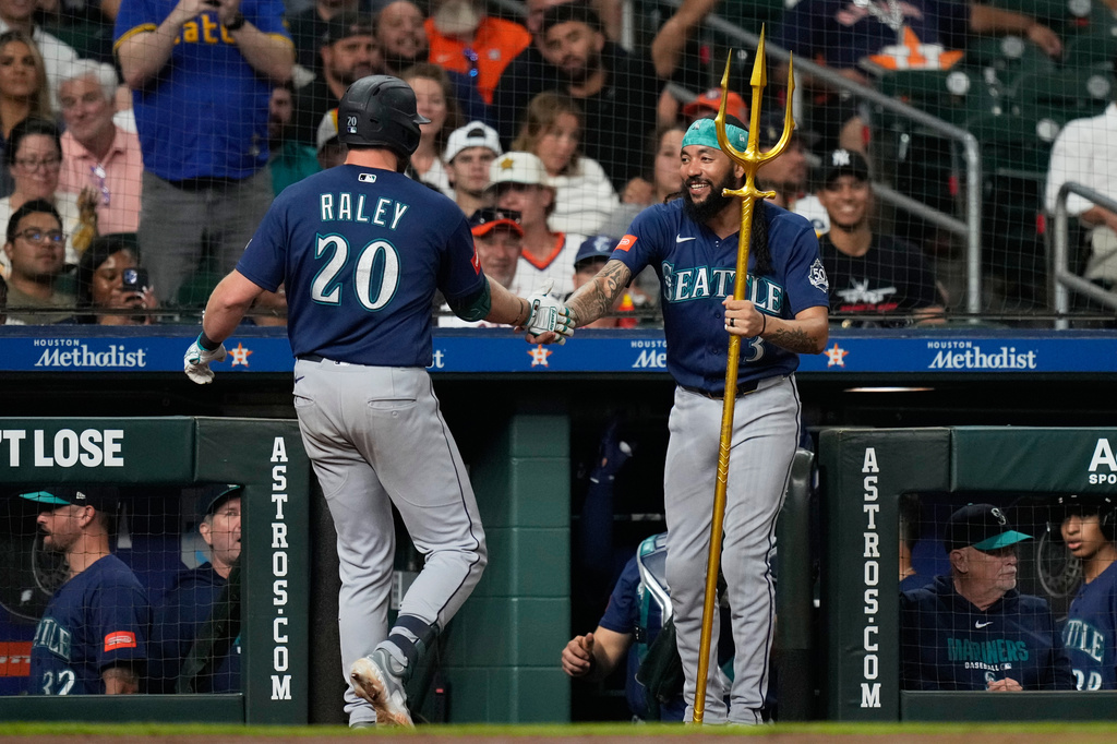 Seattle Mariners' Luke Raley (20) celebrates with J.P. Crawford (3) after hitting a home run during the sixth inning of a baseball game against the Houston Astros in Houston, Wednesday, May 13, 2026. (AP Photo/Ashley Landis)