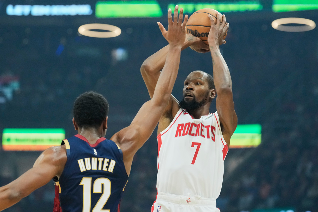 Houston Rockets forward Kevin Durant (7) shoots over Cleveland Cavaliers forward De'Andre Hunter (12) in the first half of an NBA basketball game Wednesday, Nov. 19, 2025, in Cleveland. (AP Photo/Sue Ogrocki)