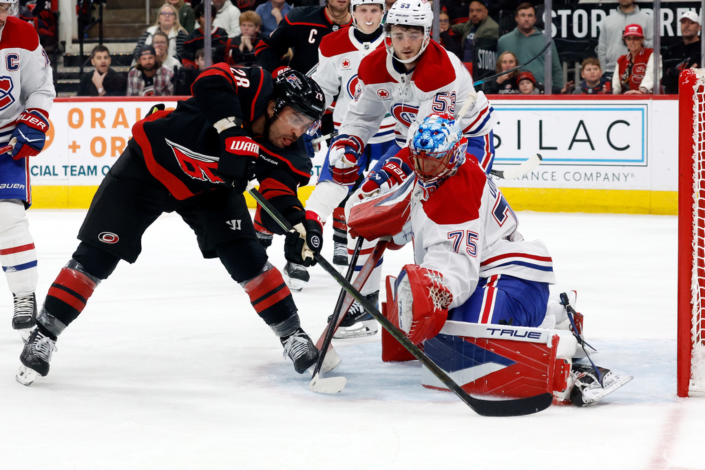 Carolina Hurricanes' William Carrier (28) has his shot blocked by the skate of Montréal Canadiens goaltender Jakub Dobes (75) to prevent a goal during the second period of an NHL hockey game in Raleigh, N.C., Thursday, Jan. 1, 2026. (AP Photo/Karl DeBlaker)