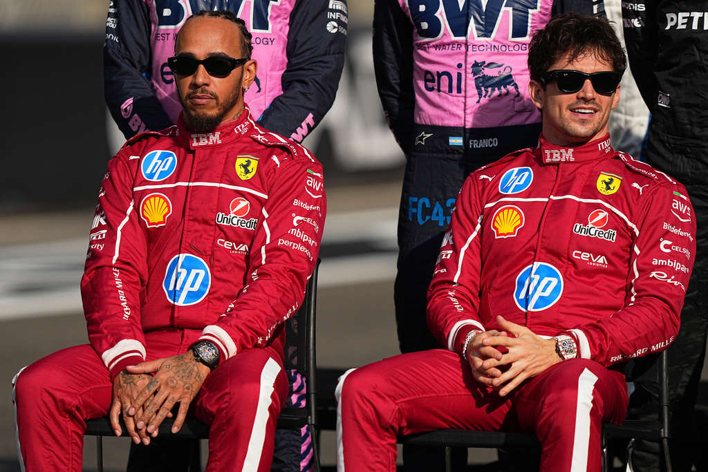 Ferrari driver Lewis Hamilton of Britain, left, and Ferrari driver Charles Leclerc of Monaco attend the drivers parade ahead of the Formula One Abu Dhabi Grand Prix at the Yas Marina Circuit in Abu Dhabi, UAE, Sunday, Dec. 7, 2025. (AP Photo/Fatima Shbair)