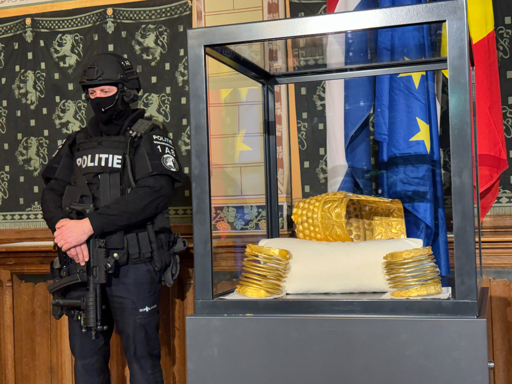 A Police officer stands by a stolen artefact from Romania, the 2,500-year-old Cotofenesti helmet, recovered in Netherlands, is shown during a press conference in Assen, Netherlands, Thursday, April 2, 2026. (AP Photo/Aleksandar Furtula)