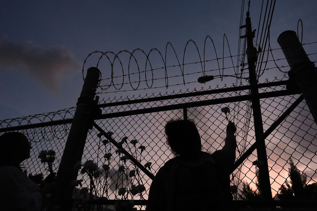 FILE - People place flowers on a fence outside Krome Detention Center in Miami, Saturday, May 24, 2025, during a vigil to recognize people who have died in U.S. Immigration and Customs Enforcement custody as well as those affected by mass deportations. (AP Photo/Rebecca Blackwell, File)