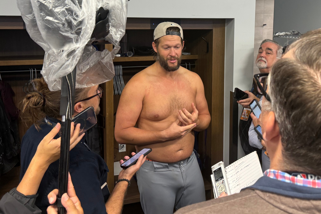 Clayton Kershaw, center, of the Los Angeles Dodgers addresses reporters for the last time as player after the Los Angeles Dodgers beat the Toronto Blue Jays 5-4 on Sunday, Nov. 2, 2025 in Toronto, Canada. (AP Photo/Rob Gillies)