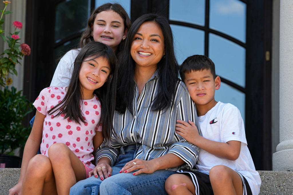 Monette Wagner poses with her children, Vivienne, 12, top left, Ellie, 9, left, and Xavier, 7, at her home her home in Indianapolis, Ind., Tuesday, Aug. 18, 2026. (AP Photo/Michael Conroy)