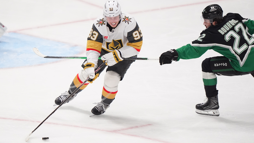 Vegas Golden Knights right wing Mitch Marner (93) skates with the puck against Dallas Stars center Mavrik Bourque (22) during the third period of an NHL hockey game Sunday, March 22, 2026, in Dallas. (AP Photo/LM Otero)
